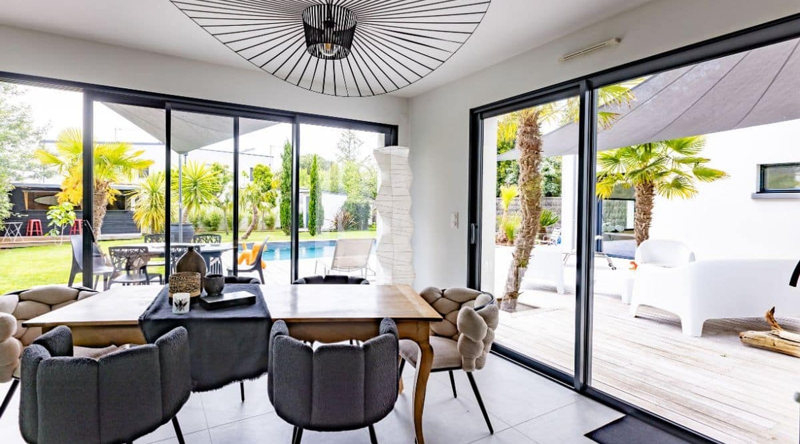Baie vitrée coulissante aluminium ouvrant sur terrasse et piscine — menuiseries Green Confort